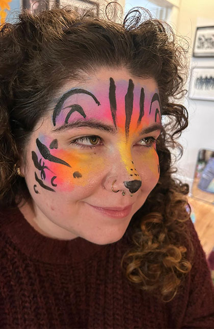 Photo of woman with rainbow lepord facepaint