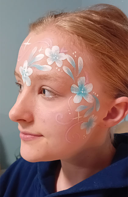 Photo of woman with blue and white flower facepaint
