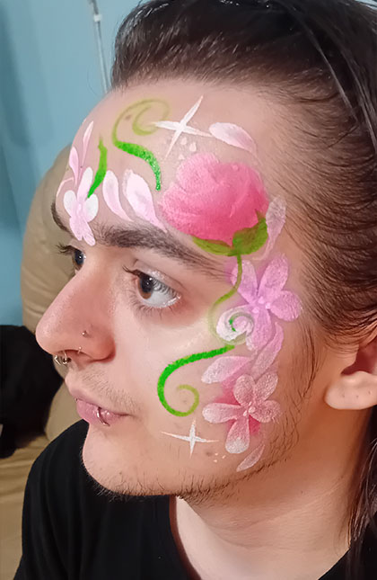 Photo of person with pink and green flower facepaint