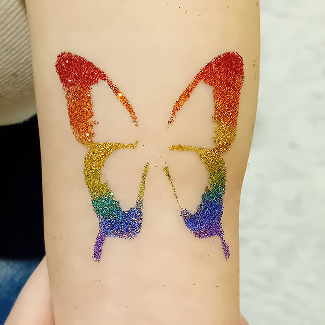 Photo of rainbow butterfly glitter tattoo